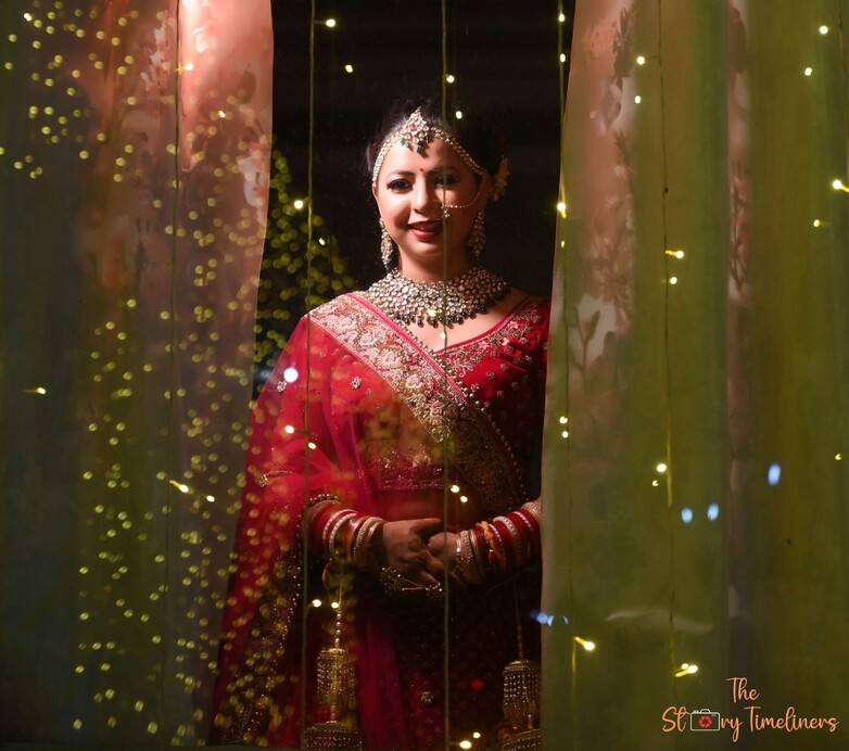 Bride standing behind lights and curtains in a cinematic portrait