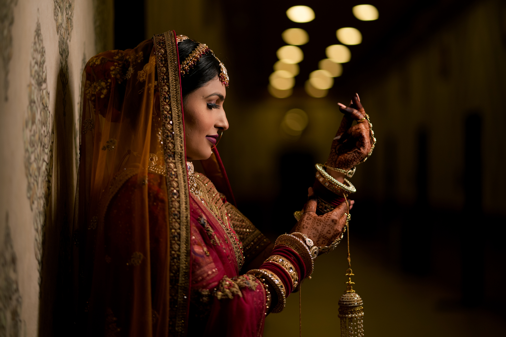 Bride adjusting her chuda in a graceful portrait
